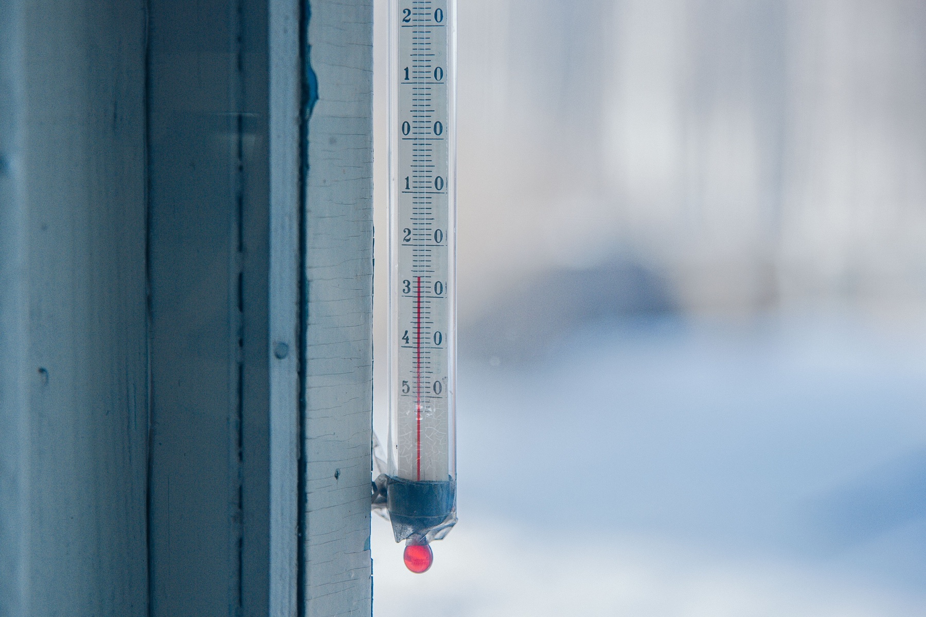 Outdoor thermometer in snow showing a temperature below −30 °C.